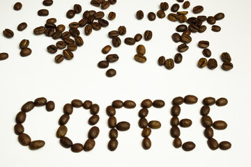 The word COFFEE is laid out on a white background with coffee beans. Coffee beans are scattered at the top