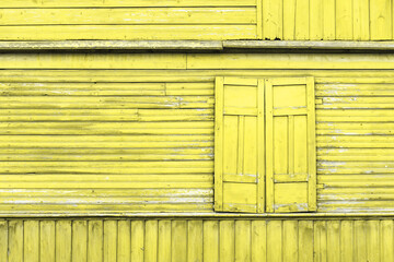 Yellow paint wooden window. Closed shutter rustic cottage house. Empty copy space wood wall. Countryside old europe architecture.
