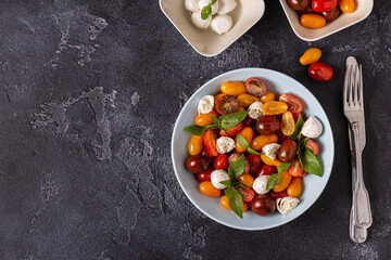 Italian caprese salad with tomatoes, mozzarella cheese, basil, olive oil.