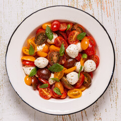 Traditional Caprese salad made of sliced fresh tomatoes, mozzarella cheese and basil