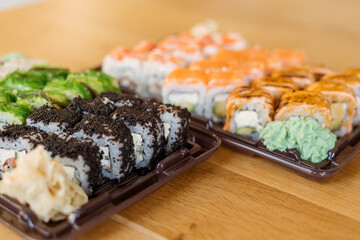Sushi Roll Delivery. Salmon, eel, tuna, avocado, royal prawn, cream cheese Philadelphia, caviar tobica, chuka, sea cabbage shrimps on wood background