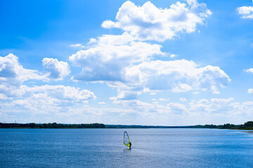 windsurfing. athlete on the water. water tourism. landscape of the river and clouds. outdoor...