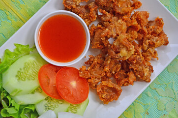 Crispy fried chicken tendons with chili sauce and vegetable in white plate