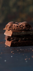 Stack of dark chocolate with cacao powder.
