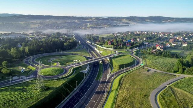 New motorway junction in Poland on national road no 7, E77, called Zakopianka.  Overpass crossroad with traffic circles, viaducts  and slip roads near Rabka. Aerial video. Far view of Tatra Mountains