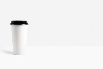 White paper cup for coffee or tea with black lid. Mockup for branding.