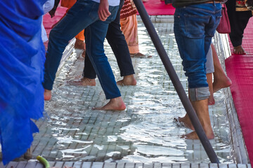 selective focused view of people washing their feet while entring in the golden temple shri...
