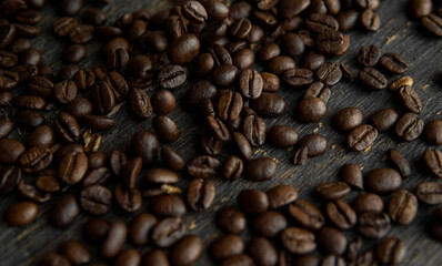 Roasted arabica coffee beans scattered on a wooden table. Fresh coffee beans.