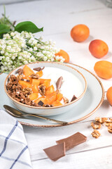 Healthy breakfast with granola, chocolate, apricots and yogurt