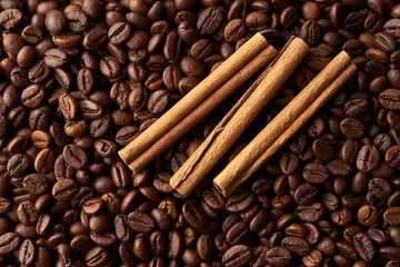 Cinnamon sticks on a heap of roasted whole coffee beans