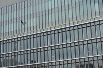 Fototapeta na wymiar A man cleaning the windows of a building