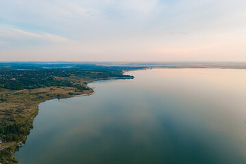Aerial view of the picturesque landscape of land, trees, sky reflected in to the water. Go into the wild. Discover earth places.