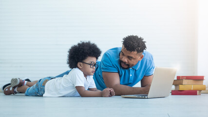 African dad helping Black son in e-learning. Online learning, teaching safety internet using.