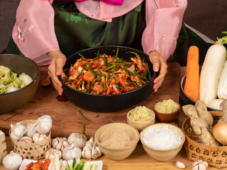 Close up, Asian woman wearing traditional costume, Hanbok holding bowl of Kimchi, Korean famouse fermented side dish.