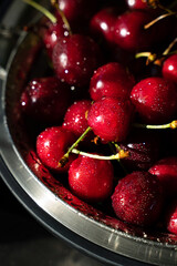 Red cherries in drops of water in a bowl