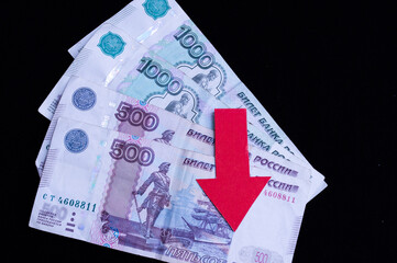 banknotes of one thousand rubles and five hundred rubles on a black background with a red down...