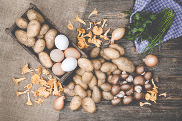 PotatoPotatoes, mushrooms, eggs,parslex,chive and onions on a wodden table with burlap.