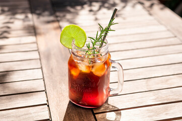 Cold brewed coffee as summer drink with ginger ale and rosemary in a mason glass