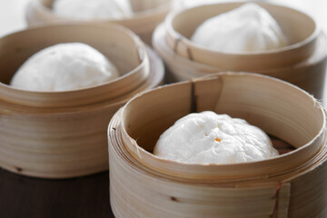 hot red pork steamed stuff bun or white bread with point in wooden basket for morning food or breakfast and dim sum snack at restaurant