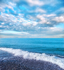 White waves of Black Sea with reflections of curly dramatic clouds