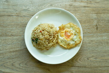 spicy stir fried chop pork with chili and basil leaf mixed rice topping egg on plate