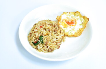 spicy stir fried chop pork with chili and basil leaf mixed rice topping egg on plate