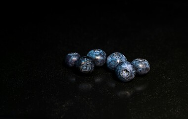Blueberries scattered on a dark background © flik47