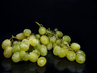 Sweet green grapes on a black background