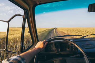 View from behind the steering wheel over rye field