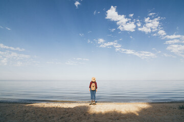 Woman with backpack overlooking the sea at sunrise