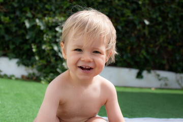 Beautiful blond baby very happy in the garden