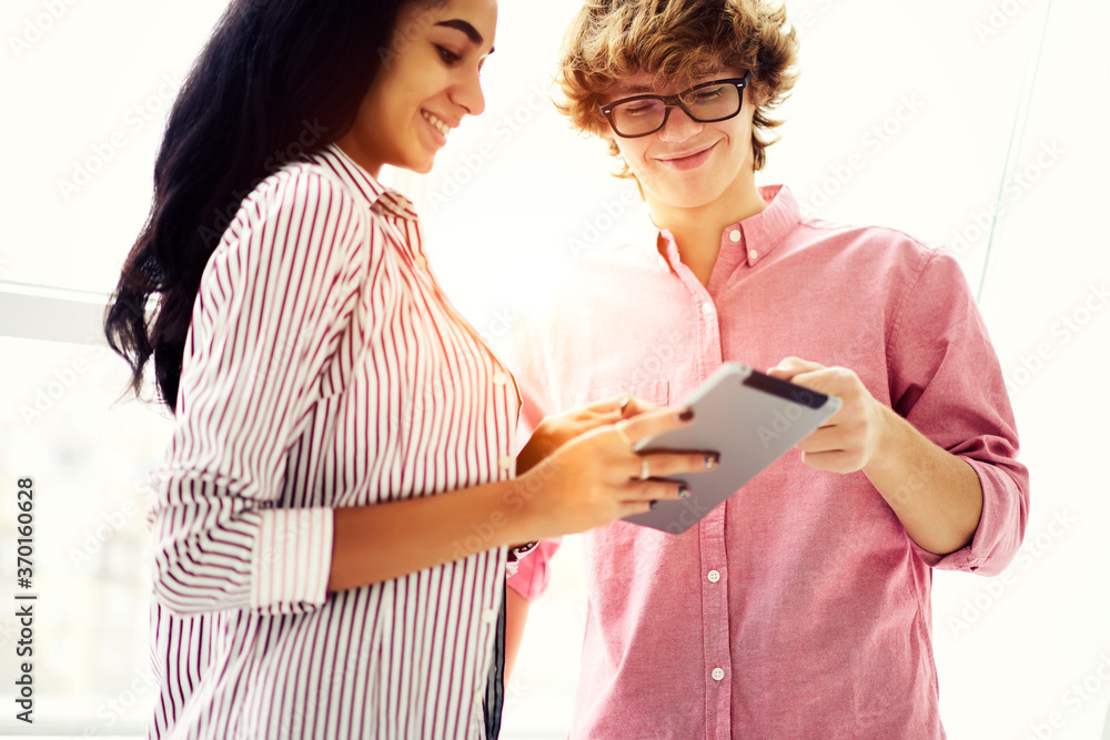 Poster young skilled marketing experts using application for making advertising content via modern touchpad