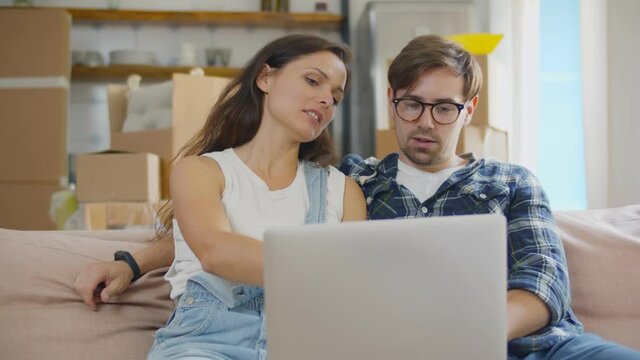 Happy Young Couple Using Laptop Choosing Moving Service