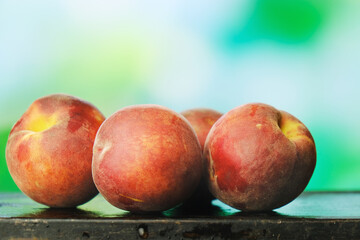 Fresh peaches on natural green background. Summer harvest of peaches, fruits background.