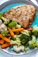 Steamed vegetables and baked turkey on a plate. Broccoli, cauliflower and carrots, diet