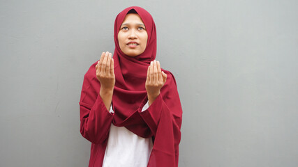 Asian muslim woman prays to God, praying gesture hands raised up, Islam religion spiritual life