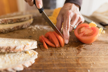 Woman slicing tomato for sandwiches