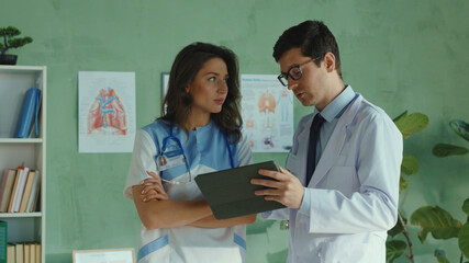 Team of medical workers cooperating in the private clinic office. Doctor and nurse discussing...