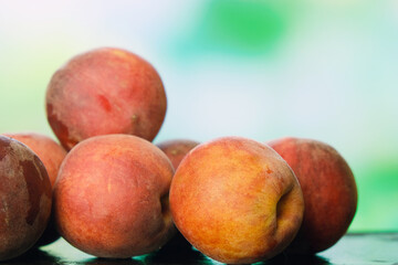 Heap of fresh peaches on natural green background. Summer harvest of peaches. Fruits background.