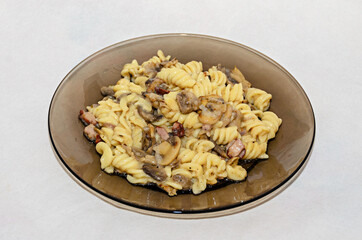 Transparent plate with pasta spaghetti carbonara with cream, mushrooms, bacon