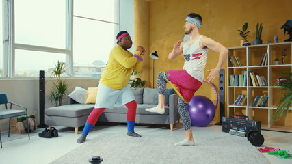 Fake fitness. Multi-ethnic guys go in for sports stretching with resistance band loops doing the...