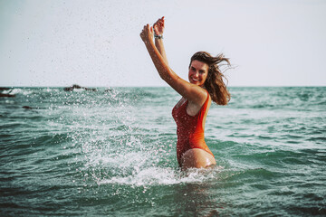 Chica playa bañador verano cadiz sur españa alegre feliz disfrutando de vacaciones libertad joven baño mar agua