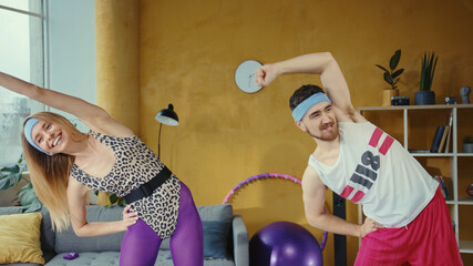 Funny caucasian retro couple doing warm-up aerobics exercises together. Female and male fitness...