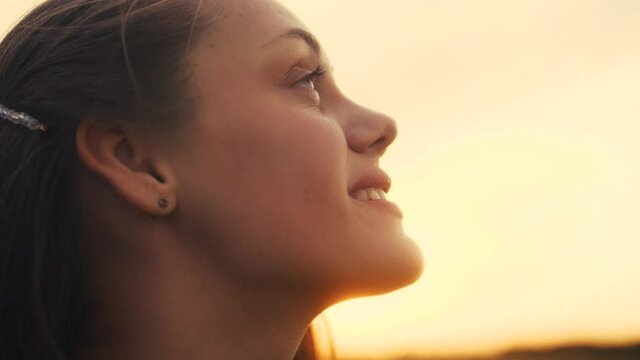 happy girl teen child closed her eyes dreams. teenager kid wants a dream come true portrait at sunset. woman daughter silhouette dreaming of a happy childhood. free face sister side view thinks
