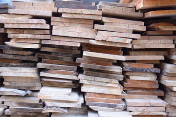 Heaps of natural wood planks in a building factory.