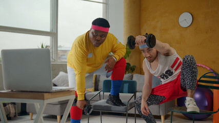 Ridiculous weird couple of fitness beginners doing arm exercises on biceps with dumbbels in wrong...
