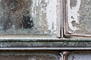 Old, dry and cracked window sealing peeling off between the glass and the metal frame