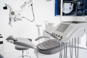 Interior of dental practice room with chair, lamp, display and stomatological tools
