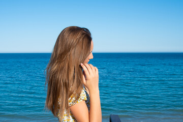 Fototapeta na wymiar Profile of a pretty girl on the beach