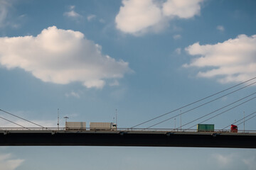 zwei Lkw mit Containern auf dem Anhänger fahren über eine Brücke 